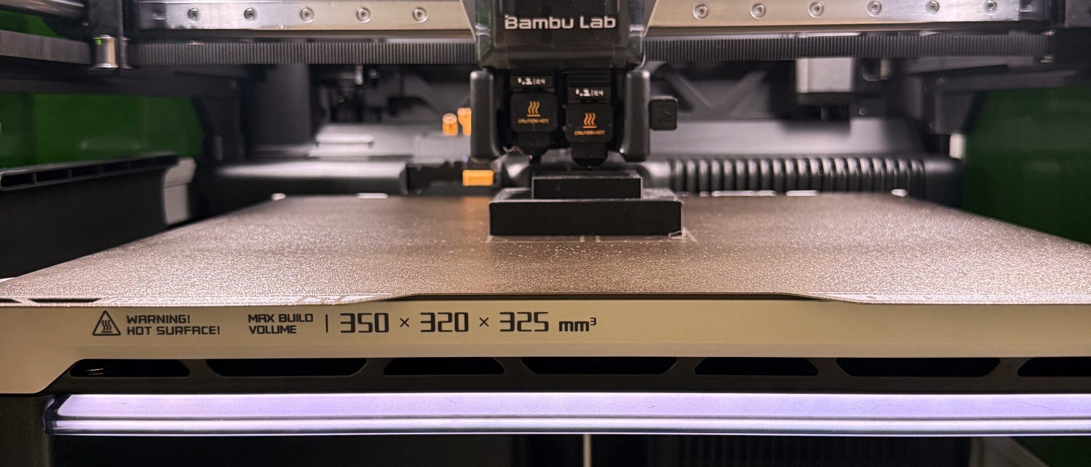 BambuLab H2D 3D-Drucker mit Dual-Nozzle-Druckkopf über dem Druckbett